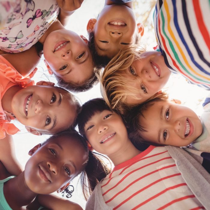 Portrait of schoolkids forming huddle 993215